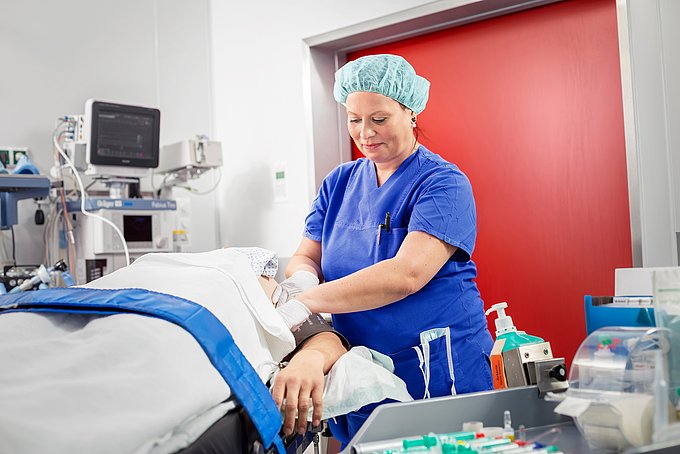 Dies ist eine Pflegekraft der Anästhesie, die einen liegenden Patienten auf eine Operation vorbereitet..