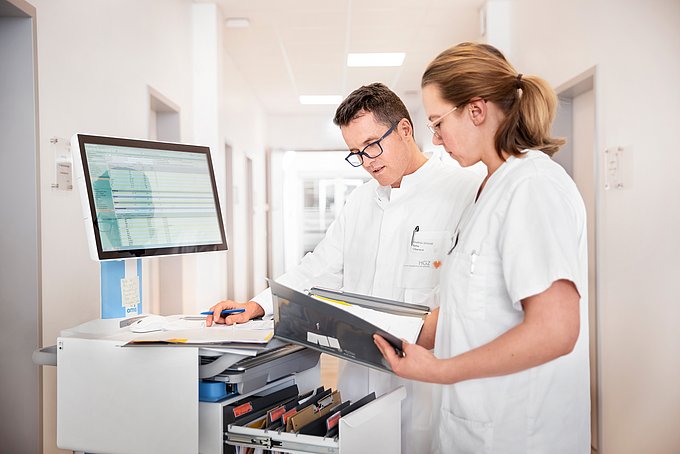Dies sind zwei Ärzte, die sich gemeinsam Patientendaten anschauen und auswerten.