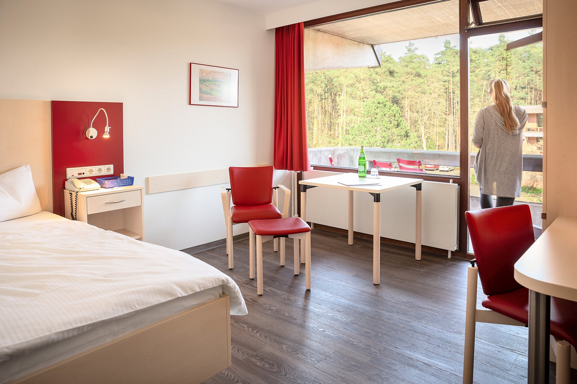 Dies ist ein Patientenzimmer mit einem Balkon und Blick ins Grüne.