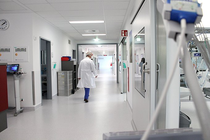 Ein Arzt geht über den Flur der Intensivstation.