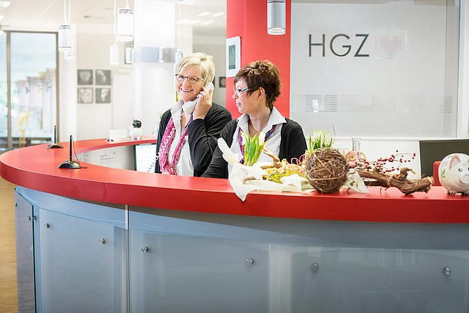 Dies sind zwei Mitarbeiterinnen am Empfangstresen des Herz- und Gefäßzentrums.