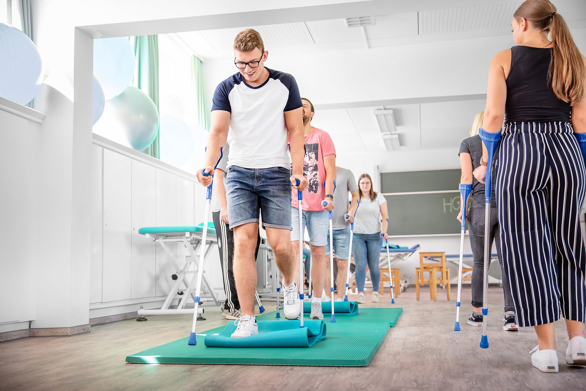HGZ | Physiotherapieschule Dies zeigt Pflegeschüler bei der Simulation mit Krücken zu gehen.